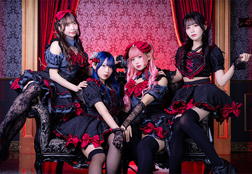 赤と黒の衣装を着たブラシュガキャストの集合写真